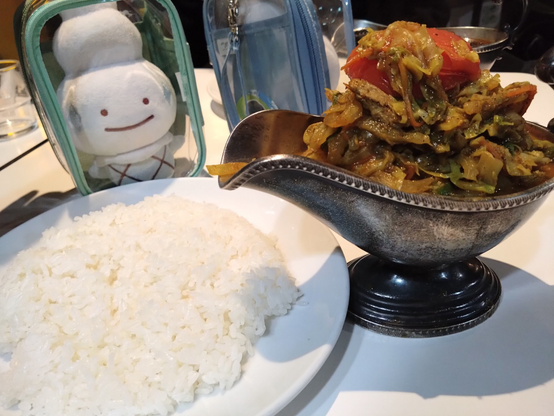 野菜山盛りのカレー(どこかに鶏肉入り)と平たいライス、バニちゃん